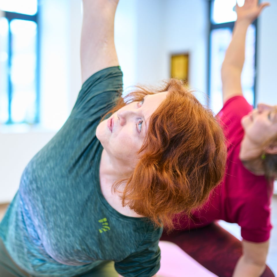 Christina Benner und eine Kursteilnehmerin in einer Yogapose.